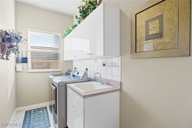 clothes washing area featuring cabinets, light tile patterned floors, separate washer and dryer, and sink