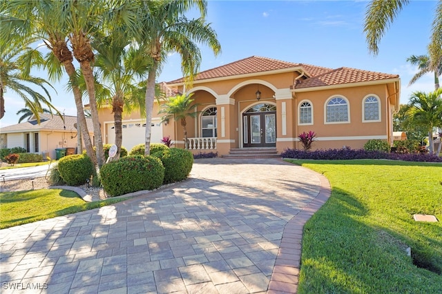 mediterranean / spanish home with french doors and a front lawn