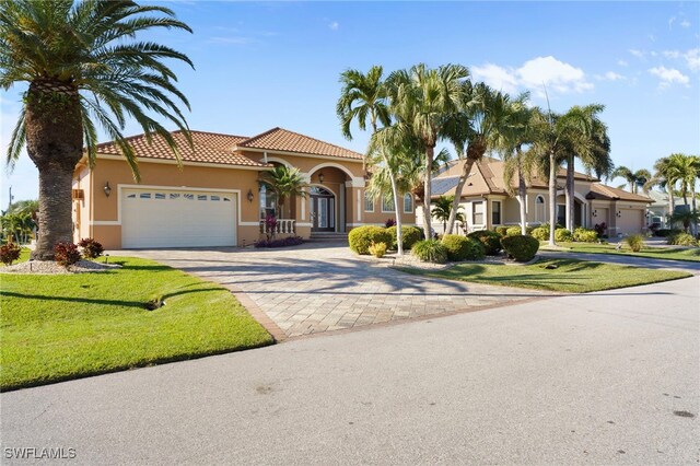 mediterranean / spanish house with a garage and a front yard