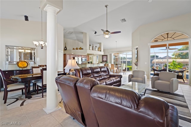 living room featuring light tile patterned floors, ceiling fan with notable chandelier, high vaulted ceiling, and ornate columns