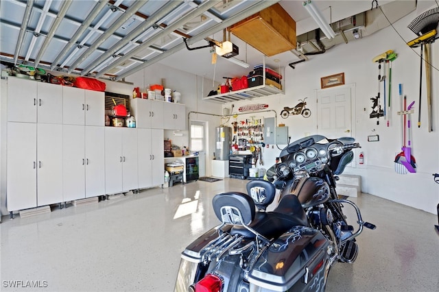 garage with a workshop area, electric panel, a garage door opener, and water heater