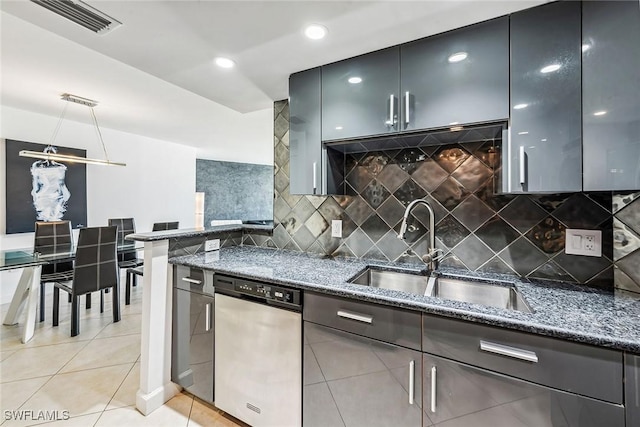 kitchen with stainless steel dishwasher, dark stone counters, sink, backsplash, and light tile patterned floors