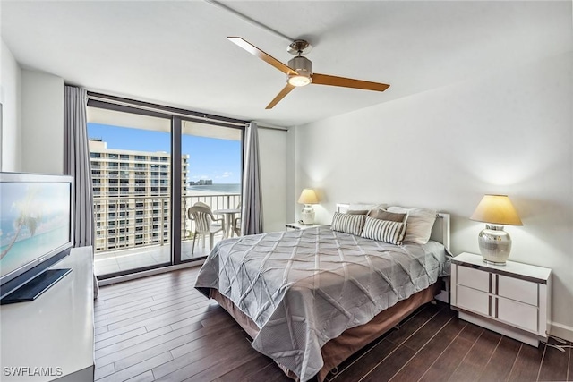 bedroom featuring ceiling fan, expansive windows, access to exterior, and dark hardwood / wood-style flooring