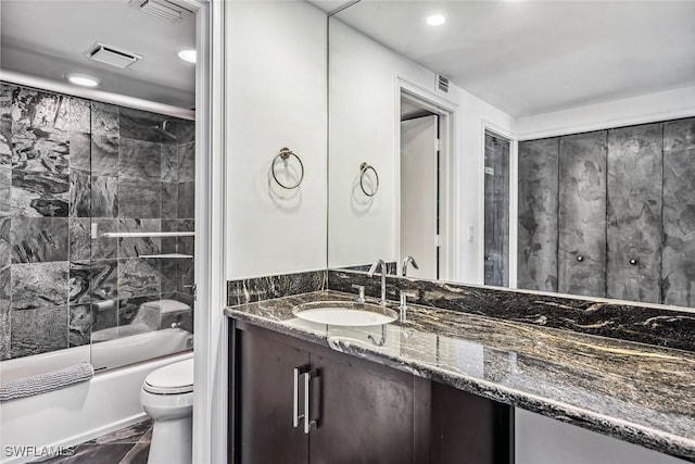 full bathroom with toilet, tile walls, enclosed tub / shower combo, and vanity