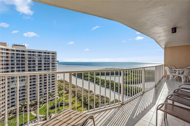 balcony featuring a water view and a view of the beach