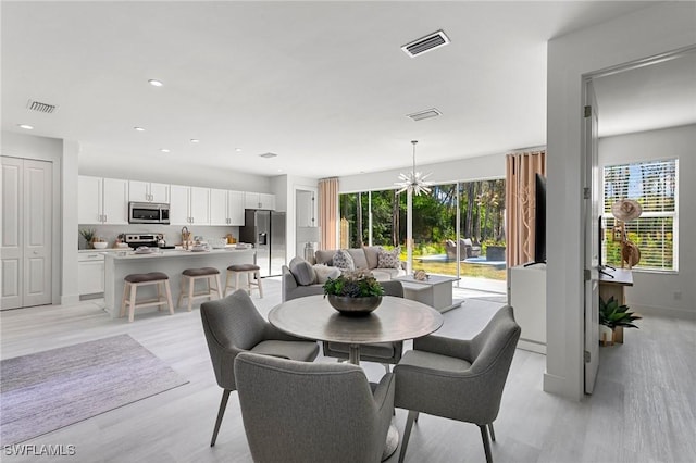 dining room with a chandelier and light hardwood / wood-style floors