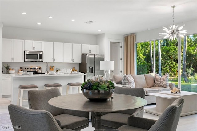 dining space with a chandelier and light hardwood / wood-style flooring