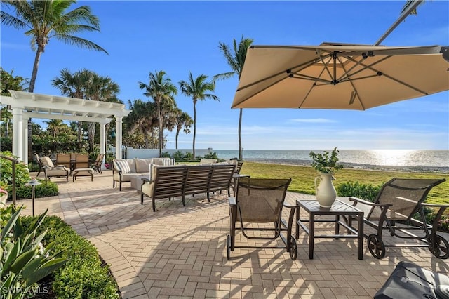 view of patio / terrace with outdoor lounge area, a pergola, a water view, and a beach view