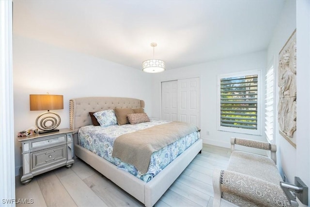 bedroom with light wood-type flooring and a closet