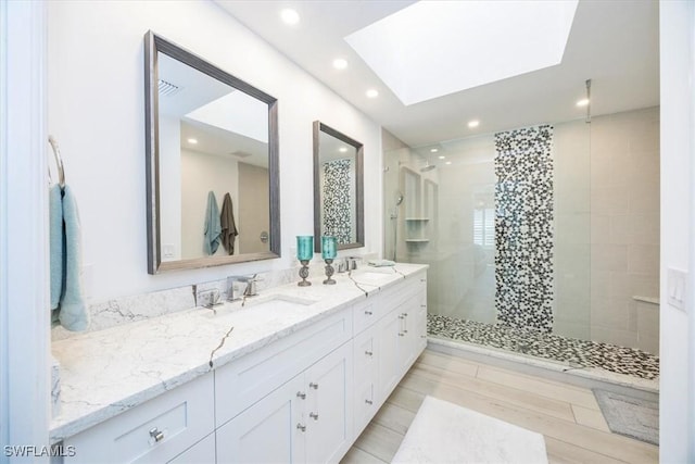 bathroom with a tile shower and vanity