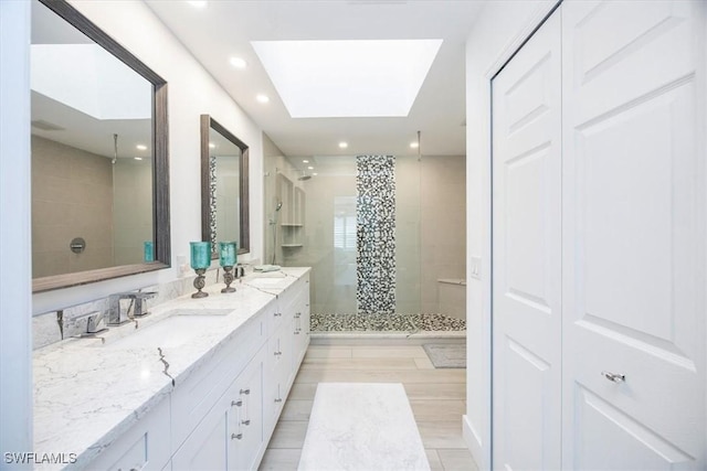 bathroom featuring vanity, walk in shower, and a skylight