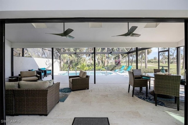 view of patio with an outdoor living space, glass enclosure, and ceiling fan