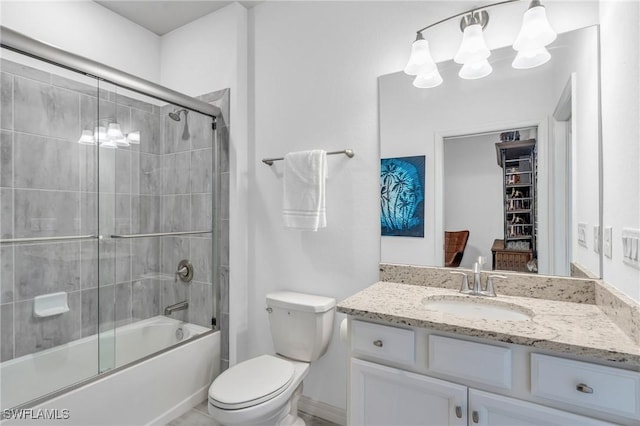 full bathroom featuring vanity, toilet, and shower / bath combination with glass door