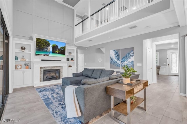 living room featuring built in shelves and a premium fireplace