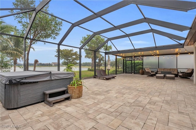 view of patio / terrace with an outdoor living space, glass enclosure, and a hot tub