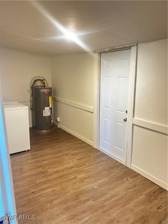 basement with hardwood / wood-style flooring, washer / clothes dryer, and water heater