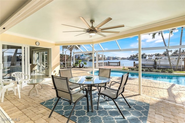 exterior space with glass enclosure, ceiling fan, and a water view