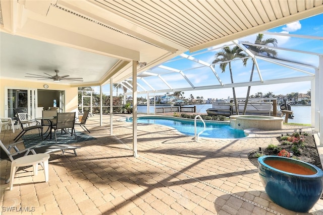 view of pool featuring ceiling fan, a lanai, a patio area, an in ground hot tub, and a water view