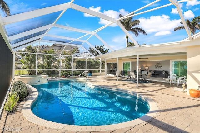 view of pool with an in ground hot tub, an outdoor living space, ceiling fan, glass enclosure, and a patio area