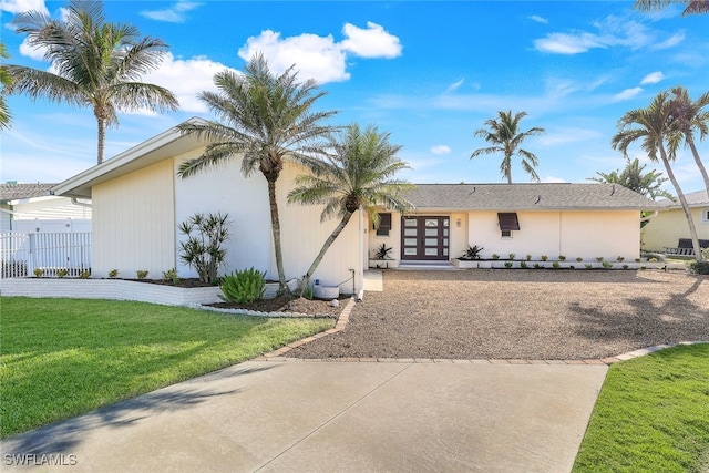 view of front facade with a front yard and french doors