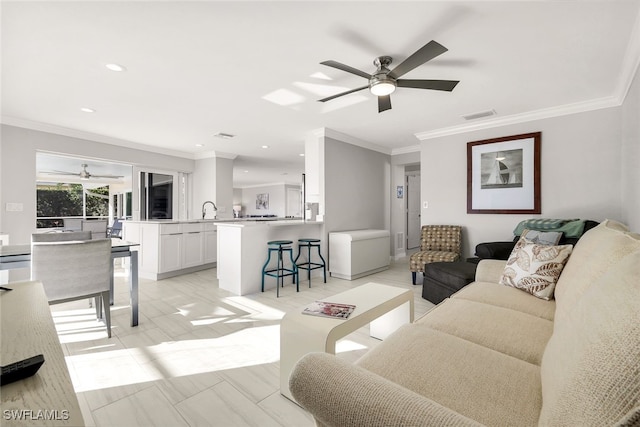 living room featuring ornamental molding and sink