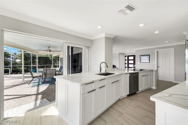 kitchen with a kitchen island with sink, white cabinets, sink, ceiling fan, and light stone counters