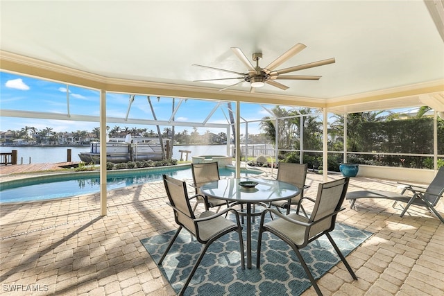 unfurnished sunroom featuring ceiling fan and a water view