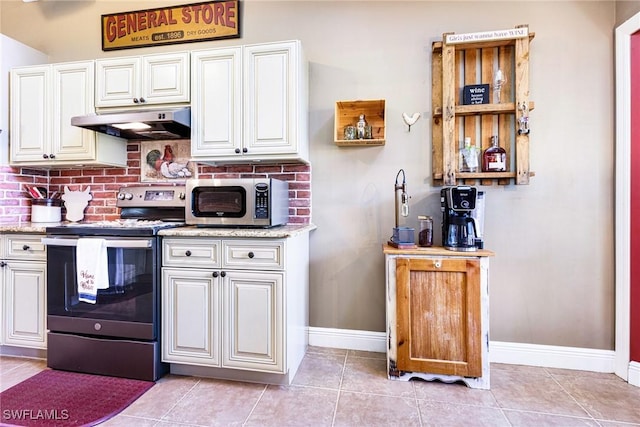 kitchen featuring appliances with stainless steel finishes, tasteful backsplash, light stone countertops, white cabinets, and light tile patterned flooring