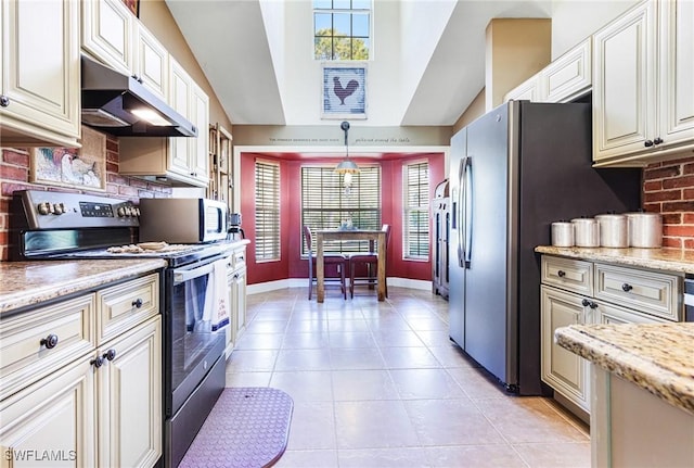 kitchen with light stone counters, stainless steel appliances, decorative light fixtures, and tasteful backsplash