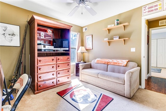 carpeted living room featuring ceiling fan