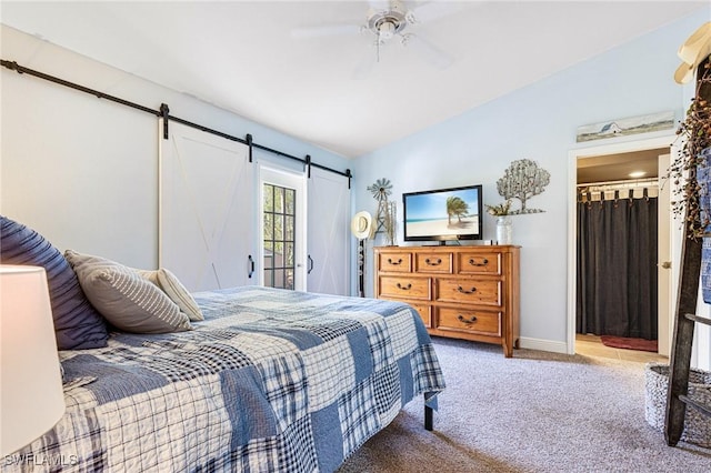 carpeted bedroom featuring a barn door, lofted ceiling, and ceiling fan