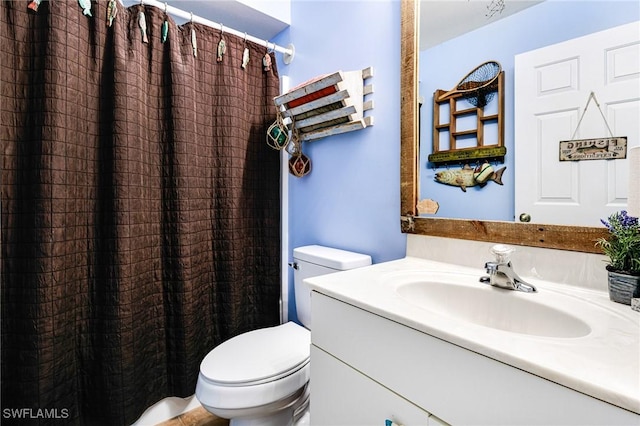 bathroom with vanity, a shower with shower curtain, and toilet