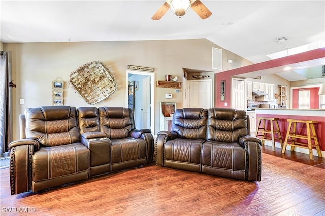 living room featuring vaulted ceiling, wood-type flooring, and ceiling fan