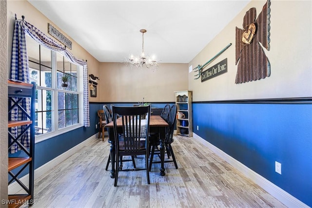 dining room with hardwood / wood-style floors and an inviting chandelier