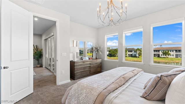 carpeted bedroom featuring an inviting chandelier