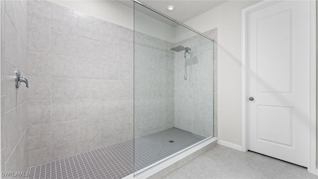 bathroom with tile patterned flooring and tiled shower