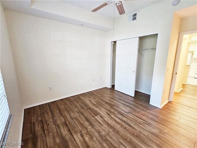 unfurnished bedroom with wood-type flooring, a closet, and ceiling fan