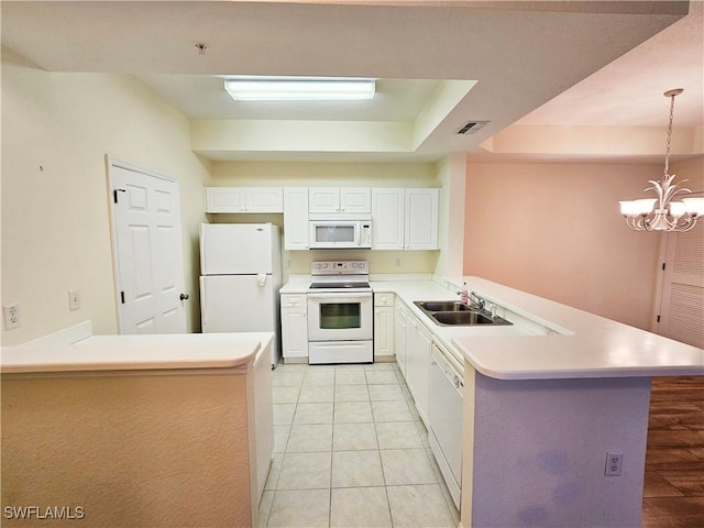 kitchen featuring sink, a notable chandelier, kitchen peninsula, decorative light fixtures, and white appliances