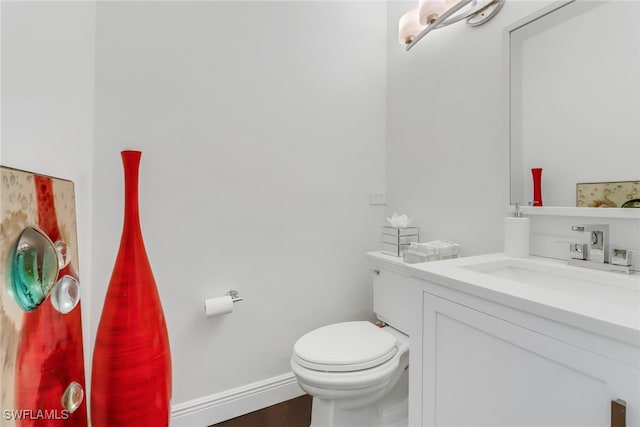 bathroom with vanity, toilet, and baseboards