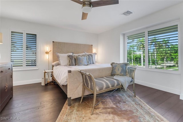 bedroom with dark wood finished floors, baseboards, visible vents, and a ceiling fan