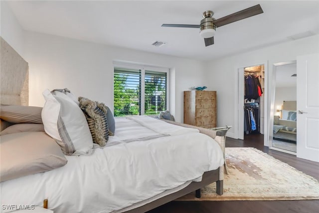 bedroom with visible vents, dark wood-type flooring, a ceiling fan, a closet, and a spacious closet