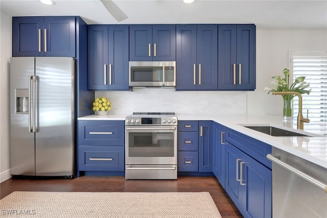 kitchen featuring a sink, stainless steel appliances, blue cabinetry, and light countertops