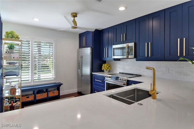 kitchen with high end appliances, ceiling fan, light countertops, blue cabinets, and backsplash