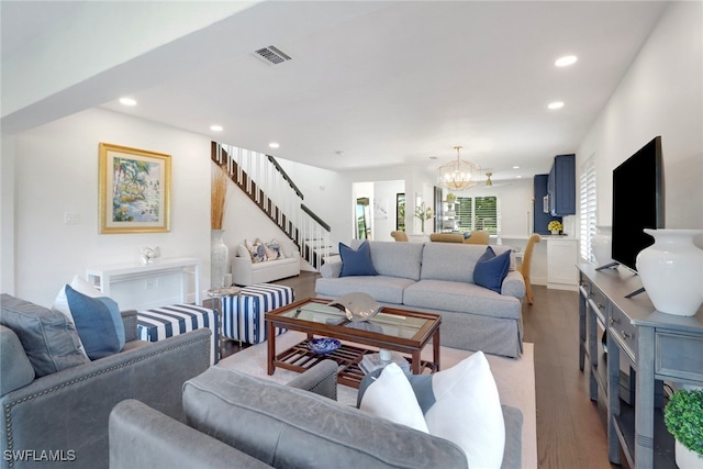 living area featuring a notable chandelier, visible vents, recessed lighting, and stairway