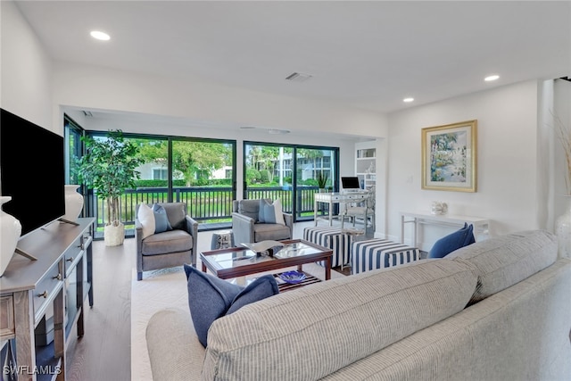 living room with wood finished floors, recessed lighting, and visible vents