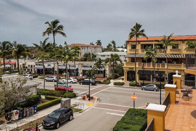 view of asphalt street featuring curbs, street lighting, and sidewalks