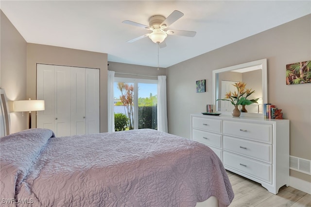 bedroom with ceiling fan, a closet, and light hardwood / wood-style floors