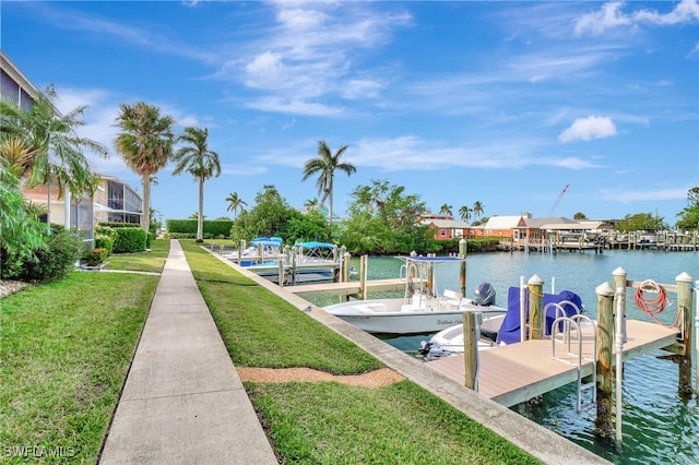 view of dock with a yard and a water view