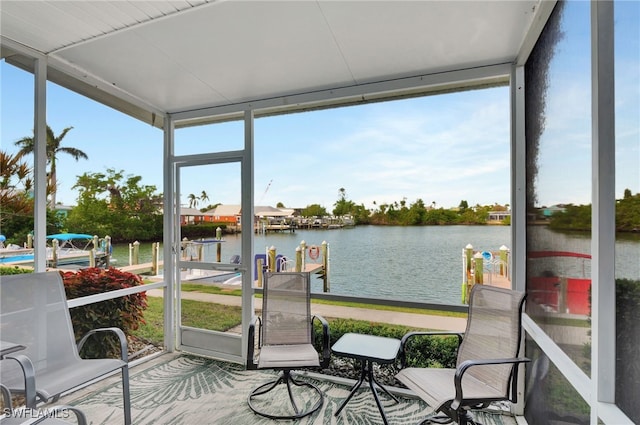 sunroom featuring a water view