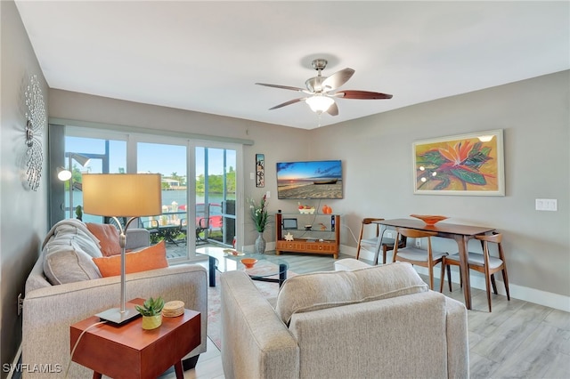 living room with light hardwood / wood-style flooring and ceiling fan